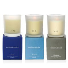 three candles sitting next to each other in front of a blue box with the words hudson grace on it