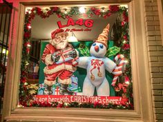 a christmas window display with santa and snowman