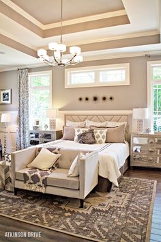 a bedroom with a bed, chair and chandelier in the middle of it