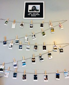 several polaroid pictures are hung on clothes pins and pinned to the wall with clothes pins