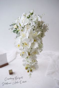 a bridal bouquet with white orchids and greenery