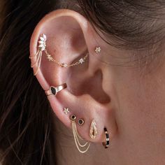 a woman wearing ear piercings with black and white stones on the inside of her ears