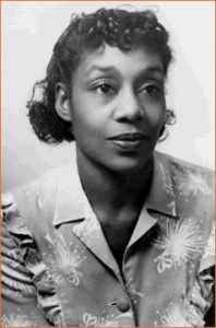 an old black and white photo of a woman with curly hair, wearing a shirt