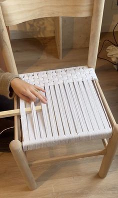 a person sitting in a chair with their hand on the seat