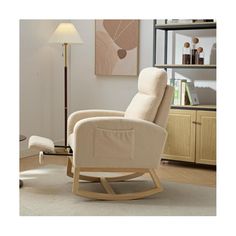 a rocking chair in a living room with a lamp on the floor and pictures above it