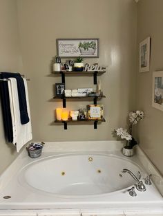 a bathroom with a large white bathtub and shelves on the wall above it's head