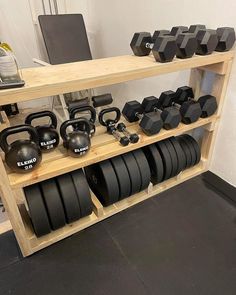 a rack with black plates, kettles and dumbbells on it in a gym