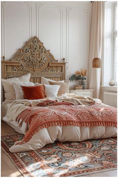 a bed with an orange and white comforter on top of it next to a window