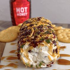 a cracker covered in cheese and toppings next to crackers on a table