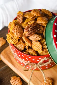 a red bowl filled with cheetos sitting on top of a wooden table