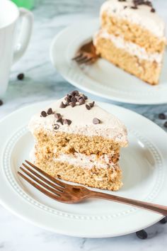 two plates with slices of cake on them and a fork in front of the plate