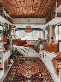 the inside of a camper with lots of pillows and rugs