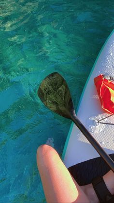 a kayak with an oar and paddle in the water next to someone's feet