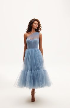 This light blue one-shoulder A-line midi dress features a puffy tulle skirt with a short underskirt, a lace-up corset bustier, and an asymmetrical sheer sleeve. Material: Tulle Composition: 100% polyester Skirt length from waist: 35.4 inches Dress weight: 17.6 lbs Neckline: Heart-shaped Back: Lace-up corset Built-in cups Lining: Light blue short underskirt Machine wash gentle cycle up to 86°F Do not bleach Steam up to 250°F Dry cleaning allowed Do not tumble dry Dry vertical Store hanging with i Fitted Tulle Midi Dress For Bridesmaids, Fitted One-shoulder Tulle Evening Dress, One-shoulder Tulle Gala Dress, Elegant Evening One-shoulder Tulle Dress, Tulle Midi Dress With Fitted Bodice For Prom, Gala One-shoulder Tulle Evening Dress, Elegant One-shoulder Fitted Tulle Dress, One Shoulder Tulle Skirt Dress For Wedding, Elegant Fitted One Shoulder Tulle Dress