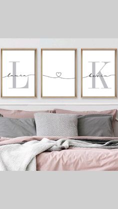 three framed pictures on the wall above a bed with pink sheets and pillows, one has a