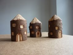 three small wooden houses sitting on top of a table