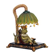 a lamp that is sitting on top of a stand with a frog underneath it and a bird perched on the base