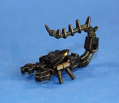 a small metal toy that is on a blue surface with it's arms and legs extended