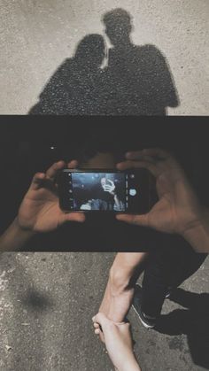 two people are holding up their cell phones to take pictures with the same person's shadow