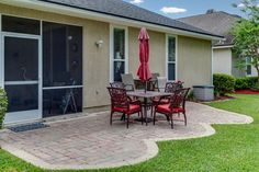 a patio with an umbrella and chairs on it