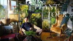 a man sitting in a chair with plants on the wall behind him and an advertisement for plant tour