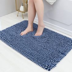 a woman is standing on the edge of a bathtub with her feet propped up