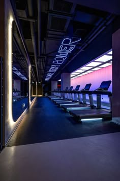 an empty room with rows of chairs and neon lights