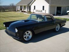 a black car parked in front of a house