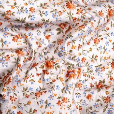 an orange and blue flowered print on white fabric