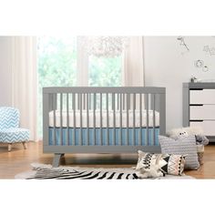 a baby's room with a crib, dresser and chair