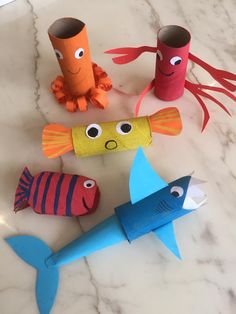 some toilet paper rolls are decorated with fish and sea creatures as well as other items