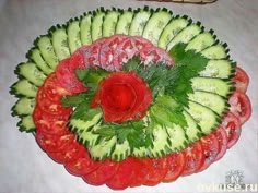 a platter filled with cucumber, tomatoes and other vegtables