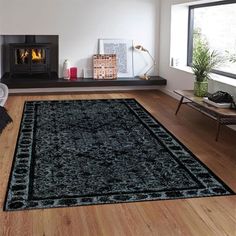 a living room filled with furniture and a rug on top of a hard wood floor