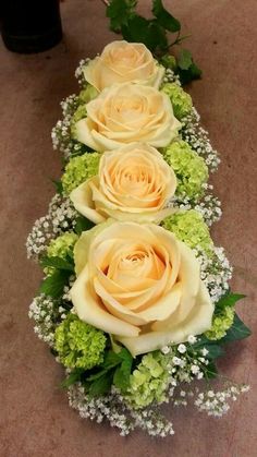 four roses are arranged in a row on the floor next to some baby's breath flowers