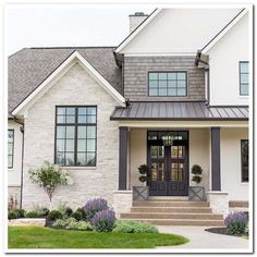 a white house with gray trim and black doors on the front door is shown in this image