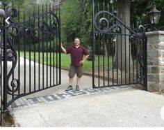 a man standing in front of an iron gate