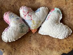 three heart shaped pillows sitting on top of a wooden table