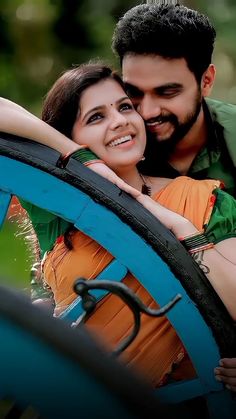 a man and woman hugging each other in front of a tire