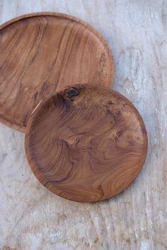 two wooden plates sitting on top of a table