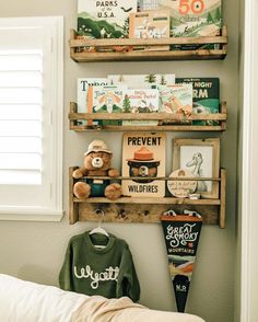 two wooden shelves holding books and stuffed animals on top of a bed next to a window