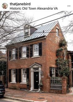 an old brick house with black shutters on the front and side windows is shown