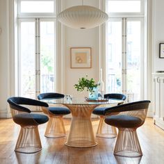 a dining room table with four chairs and an oval glass top centerpiece in the middle