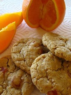 three cookies and an orange on a table