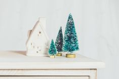 a small house and trees on top of a table with the words 10 ways to save money this christmas & not go into debt