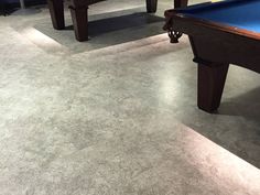 a pool table and two chairs in a room with carpeted flooring on the walls