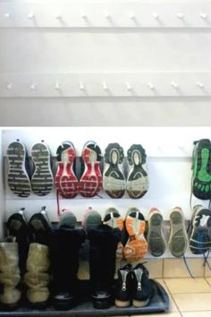 many pairs of shoes are lined up on the floor in front of a wall rack