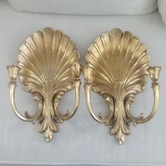 two golden sconces are sitting on a white couch in front of a pillow