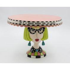 a ceramic figurine with a pink hat and glasses on it's head