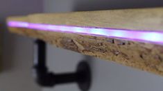 a wooden shelf with a purple light on it