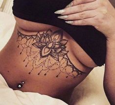 a woman laying in bed with her stomach tattoo